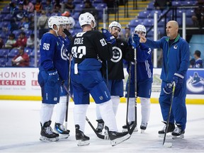 Vancouver Canucks head coach Rick Tocchet, right, talks as Ian Cole (82), Andrei Kuzmenko (96), Elias Pettersson, back left, Filip Hronek, back centre, and Nils Hoglander, back right, listen during the opening day of the NHL hockey team's training camp, in Victoria, Thursday, Sept. 21, 2023.
