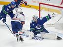 Edmonton Oilers' Adam Erne (21) scores against Vancouver Canucks goalie Thatcher Demko (35) as Ian Cole (82) defends during the first period of a preseason NHL hockey game in Vancouver, B.C., Saturday, Sept. 30, 2023.