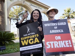 FILE - Fran Drescher, left, president of SAG-AFTRA, and Meredith Stiehm, president of Writers Guild of America West, pose together during a rally by striking writers outside Paramount Pictures studio in Los Angeles on May 8, 2023.