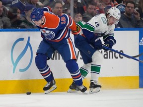 Edmonton Oilers Zach Hyman (18) is held by Vancouver Canucks Quinn Hughes (43) during first period NHL pre-season action on Wednesday, Sept. 27, 2023 in Edmonton.