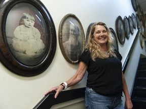 Leslie Madsen of the Mount Pleasant Furniture prop house in Vancouver. She calls this stairwell the "Wall of Death" because it's filled with old hand-tinted photos in oval frames from the early 1900s.