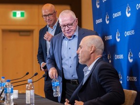 Vancouver Canucks GM Patrik Allvin (from left), president Jim Rutherford and head coach Rick Tocchet speak ahead of training camp on Wednesday.