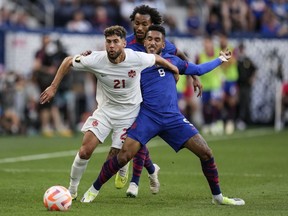 Canada midfielder Jonathan Osorio (21) moves the ball against United States forward Jesús Ferreira (9) during a CONCACAF Gold Cup semifinal soccer match on Sunday, July 9, 2023, in Cincinnati. Despite not playing, Canada dropped one spot to No. 44 in the new FIFA world rankings released Thursday.THE CANADIAN PRESS/AP/Michael Conroy