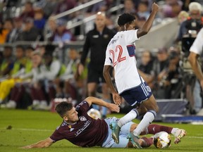 Colorado Rapids forward Diego Rubio (11) slide-tackles Vancouver Whitecaps forward Ali Ahmed (22) during the first half of an MLS soccer match Wednesday, Sept. 27, 2023, in Commerce City, Colo.