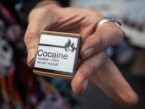 A man holds cocaine he received from the Drug User Liberation Front.