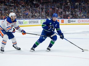 Quinn Hughes is chased by Connor McDavid on Wednesday night at Rogers Arena.