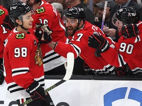 Connor Bedard #98 of the Chicago Blackhawks celebrates with Nick Foligno #17 and Tyler Johnson #90 after scoring his first NHL goal during the first period of the Boston Bruins home opener at TD Garden on October 11, 2023 in Boston, Massachusetts.