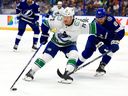 Anthony Beauvillier of the Vancouver Canucks and Erik Cernak of the Tampa Bay Lightning fight for the puck first period during a game at Amalie Arena on October 19, 2023 in Tampa, Florida.