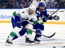 J.T. Miller of the Vancouver Canucks and Nikita Kucherov of the Tampa Bay Lightning fight for the puck first period during a game at Amalie Arena on October 19, 2023 in Tampa, Florida.