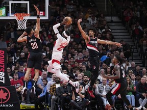 Chris Boucher #25 of the Toronto Raptors goes to the basket against Toumani Camara #33 (L), Shaedon Sharpe #17 (2nd R), and Jabari Walker #34 of the Portland Trail Blazers during the first half of the game at the Scotiabank Arena on October 30, 2023.