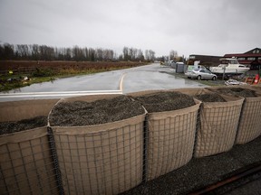 Bins of sand are placed across the road to form a temporary dike in the Huntingdon Village area of Abbotsford in 2021.