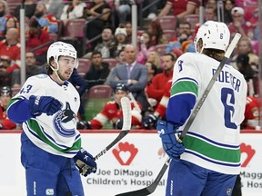 Vancouver Canucks defenceman Quinn Hughes, left, celebrates his goal with Brock Boeser during the first period against the Florida Panthers on Saturday in Sunrise, Fla.