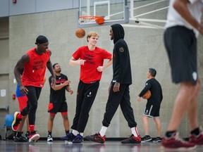 Toronto Raptors rookie Gradey Dick, centre, and point guard Dennis Schroder, left, take part in the opening day of the NBA basketball team's training camp, in Burnaby, B.C., on Tuesday October 3, 2023.