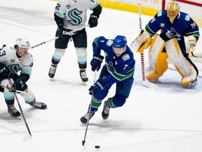 Vancouver Canucks' Carson Soucy (7) skates with the puck as Seattle Kraken's Marian Studenic defends during the first period of an NHL preseason game in Abbotsford, B.C. on Wednesday, Oct. 4, 2023.