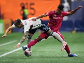 St. Louis City's Nicholas Gioacchini, back right, shoves Vancouver Whitecaps' Tristan Blackmon off the ball during the first half of an MLS soccer match in Vancouver, on Wednesday, October 4, 2023.