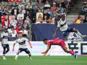 Vancouver Whitecaps' Javain Brown, top right, and St. Louis City's Nicholas Gioacchini vie for the ball during the first half of an MLS soccer match in Vancouver, on Wednesday, October 4, 2023.