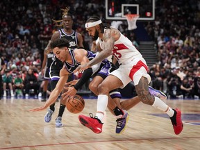 Toronto Raptors' Gary Trent Jr., front right, and Sacramento Kings' Colby Jones vie for a loose ball during the second half of a preseason NBA basketball game, in Vancouver, B.C., Sunday, Oct. 8, 2023.