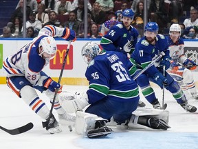 Vancouver Canucks goalie Thatcher Demko (35) stops Edmonton Oilers' Connor Brown (28) as Vancouver's Pius Suter (24) and Filip Hronek (17) watch during the third period on Wednesday, October 11, 2023.