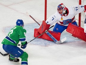 Abbotsford Canucks' Vasily Podkolzin (92) scores his first of two goals on Laval Rocket goaltender Jakub Dobes (71) during the second period in Laval on Friday.