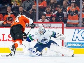 Philadelphia Flyers' Sean Couturier, left, makes a penalty shot against Vancouver Canucks' Thatcher Demko, right, during the first period on Tuesday in Philadelphia.