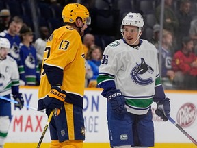Nashville Predators center Yakov Trenin (13) talks with Vancouver Canucks left wing Andrei Kuzmenko (96) before an NHL hockey game Tuesday, Oct. 24, 2023, in Nashville, Tenn.