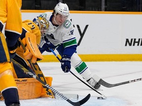 Nashville Predators goaltender Juuse Saros, left blocks a shot on goal by Vancouver Canucks left wing Anthony Beauvillier (72) during the first period on Tuesday in Nashville, Tenn.