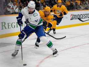 Vancouver Canucks defenceman Quinn Hughes (43) skates the puck past Nashville Predators center Ryan O'Reilly (90) during the second period on Tuesday, Oct. 24, 2023, in Nashville, Tenn.
