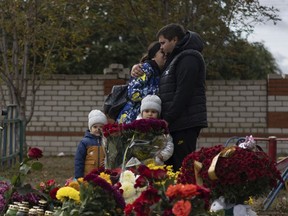 FILE - People react near the memorial for the victims of a Russian rocket attack in the village of Hroza near Kharkiv, Ukraine, Sunday, Oct. 8, 2023. A report by U.N investigators has pointed a finger at Russia as likely being responsible for the deaths of 59 civilians at a village café hit by a missile in eastern Ukraine in early October, in what was one of the deadliest strikes since the Kremlin's forces launched a full-scale invasion 20 months ago.