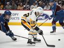 Pittsburgh Penguins defenceman Mark Friedman, right, fields the puck after driving past Colorado Avalanche defenseman Bowen Byram in the second period of an NHL hockey game Wednesday, March 22, 2023, in Denver. The Vancouver Canucks have acquired Friedman and forward Ty Glover from the Penguins.