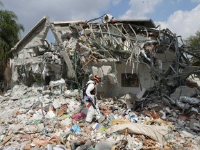 An Israeli soldier walks by a house destroyed by Hamas terrorists in Kibbutz Be'eri on Wednesday, Oct. 11, 2023.