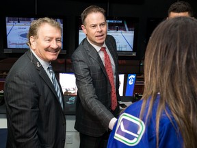 John Garrett and John Shorthouse greet a fan before a game at Rogers Arena Oct. 6, 2016