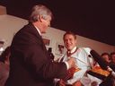 New Canucks player Pavel Bure dons his jersey on Nov. 1, 1991, with coach Pat Quinn.