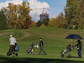 With construction cranes dotting the skyline, golfers at Langara Golf Course in Vancouver enjoy a round on Oct. 26.