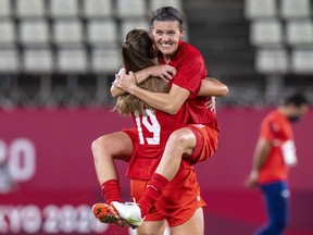 Canada forward Christine Sinclair (12) leaps into the arms of forward Jordyn Huitema (19) to celebrate their win in semifinal football action against the United States of America at the Tokyo Olympics in Kashima, Japan, Monday, Aug. 2, 2020. The star Canadian soccer player has announced her retirement.