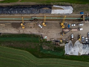 In this photograph taken with a drone, workers lay pipe during construction of the Trans Mountain pipeline expansion on farmland, in Abbotsford on May 3, 2023.