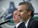 Former Vancouver Canucks General Manager Jim Benning (back) and President Trevor Linden speak to the media in April 2017.