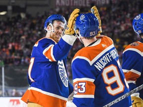 EDMONTON, CANADA - OCTOBER 29: Connor McDavid #97 (L) and Ryan Nugent-Hopkins #93 of the Edmonton Oilers celebrate after defeating the Calgary Flames during the third period of the 2023 Tim Hortons NHL Heritage Classic at Commonwealth Stadium on October 29, 2023 in Edmonton, Alberta, Canada. The Oilers defeated the Flames 5-2.