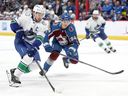 Canucks captain Quinn Hughes advances the puck against Joel Kiviranta of the Colorado Avalanche on Wednesday in Denver.