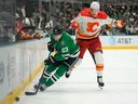 Esa Lindell #23 of the Dallas Stars skates for the puck as Nikita Zadorov #16 of the Calgary Flames jumps to avoid him during the second period at American Airlines Center on November 24, 2023 in Dallas, Texas.