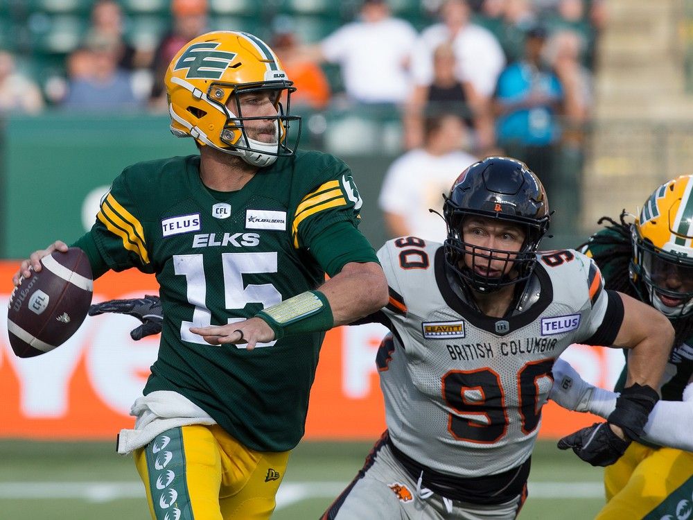 The Edmonton Elks' quarterback Taylor Cornelius (15) looks to make a pass under pressure from the B.C. Lions' Mathieu Betts (90) last season