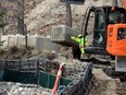 Workers began building a new retaining wall Wednesday behind Pleasant Valley Mobile Home Park.