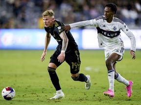 Ali Ahmed tussles with LAFC midfielder Mateusz Bogusz.