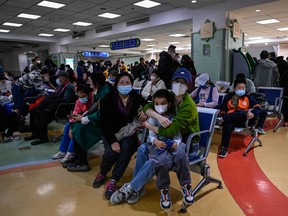 Children and their parents wait at an outpatient area at a children hospital in Beijing on Nov. 23, 2023.