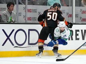 Vancouver Canucks left wing Phillip Di Giuseppe, right, passes the puck while under pressure from Anaheim Ducks centre Benoit-Olivier Groulx in April 2023.