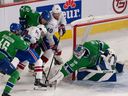 Abbotsford Canucks goaltender Arturs Silovs (31) makes a save against Laval Rocket's Joshua Roy (10) and Joel Armia (40) as Abbotsford Canucks' Filip Johansson (46) and Matt Irwin (52) defend last month in Laval.