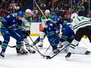 Vancouver Canucks' Dakota Joshua (81) and Filip Hronek (17) battle for the puck with Dallas Stars' Jason Robertson (21), Joe Pavelski (16), and Jamie Benn (14) during the first period of an NHL hockey game in Vancouver, on Saturday, Nov. 4, 2023.
