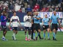 Referee Tim Ford (centre right) is followed by Vancouver Whitecaps' Ali Ahmed (centre left) and (Sam Adekugbe, back left) as he leaves the field after Los Angeles FC defeated the Vancouver Whitecaps during Game 2 of a first round MLS playoff soccer match, in Vancouver, on Sunday, Nov. 5, 2023.