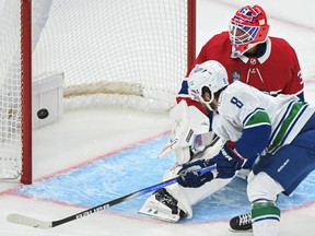 Vancouver Canucks' Conor Garland scores against Montreal Canadiens goaltender Jake Allen during second period NHL hockey action in Montreal, Sunday, November 12, 2023.