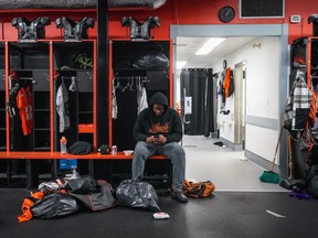 B.C. Lions defensive lineman Josh Banks uses his phone while taking a break from cleaning out his locker at the CFL football team's practice facility, in Surrey, B.C., on Monday, November 13, 2023.
