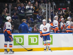 New York Islanders' Bo Horvat, centre, acknowledges applause and a standing ovation from the crowd while being honoured by his former team, the Vancouver Canucks, during a stoppage in play during the first period on Wednesday, November 15, 2023.